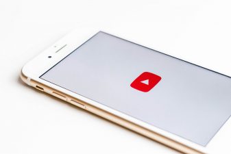 Puhelin on valkoisella tauastalla ja siinä auki YouTuben logo